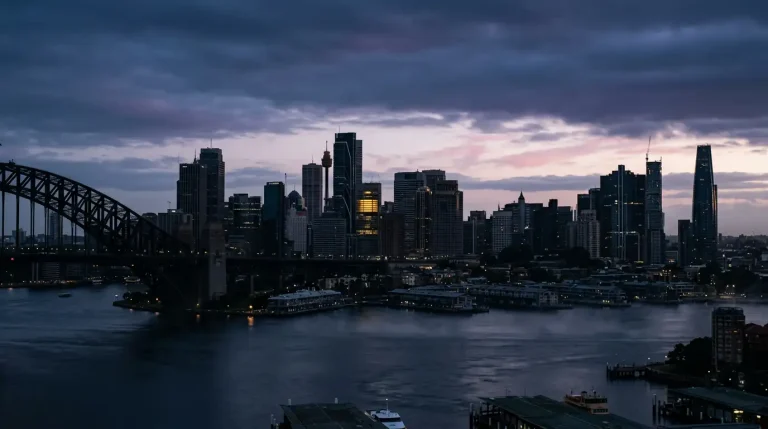 Early morning Sydney skyline with a single lit office window